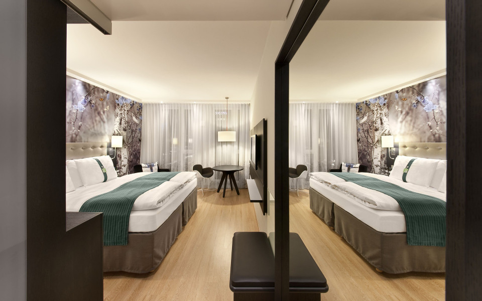 Modernes Hotelzimmer mit gro&szlig;em Spiegel und Bett