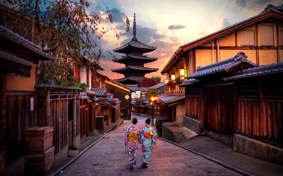 Zwei Geishas in traditionellen japanischen Kimonos zwischen der Yasaka-Pagode und der Sannen-Zaka-Stra&szlig;e in Kyoto, Japan. 